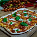 a pizza sitting on top of a wooden cutting board