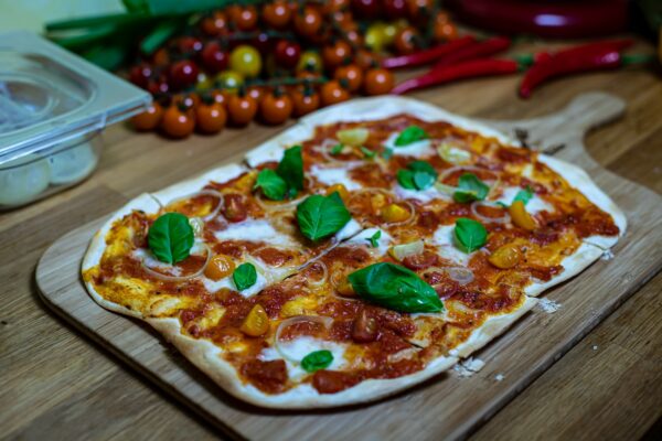 a pizza sitting on top of a wooden cutting board