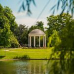 a gazebo in a park next to a lake