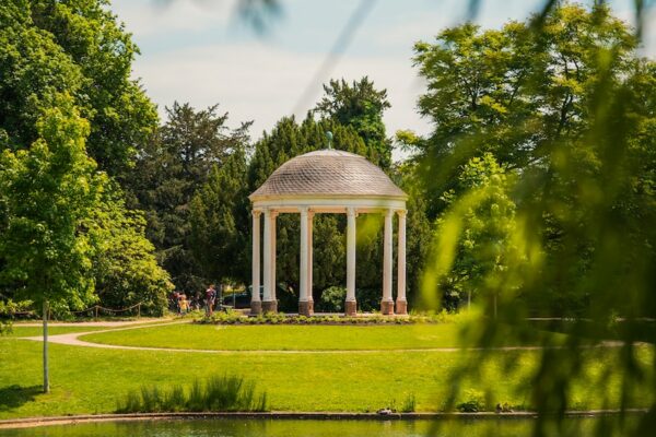 a gazebo in a park next to a lake