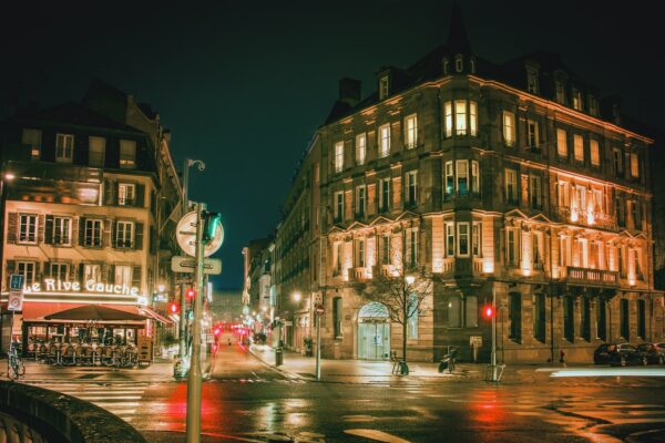 street photography of roads between buildings at night