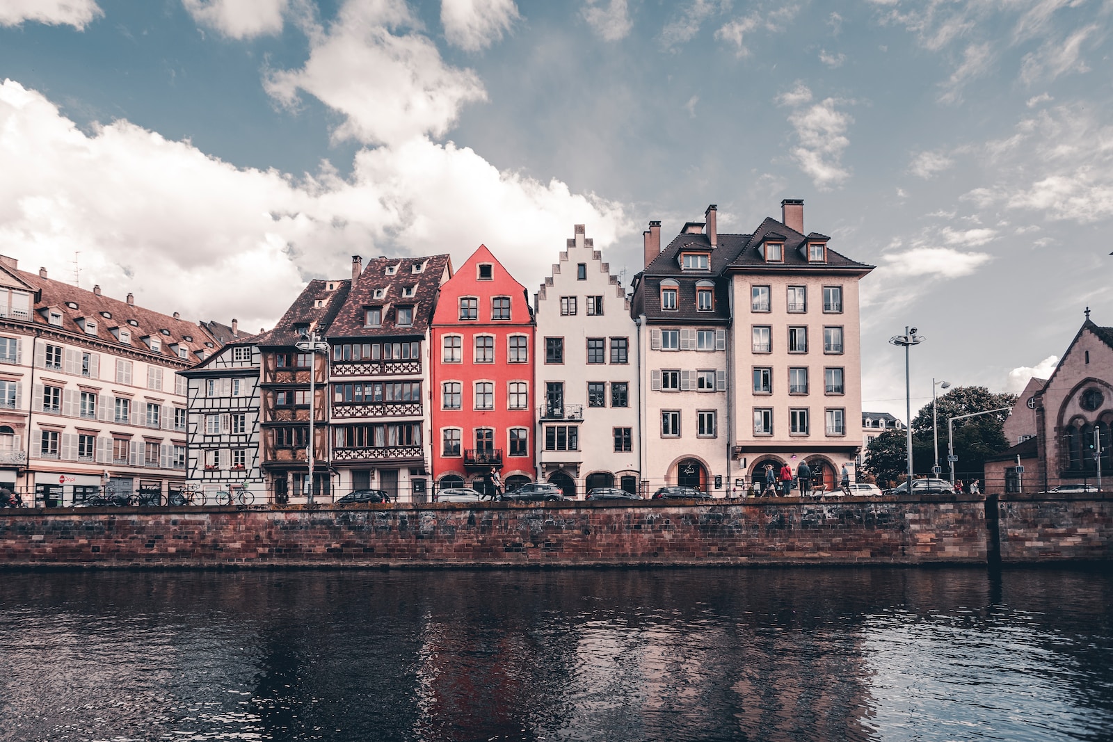 white and red concrete building beside body of water during daytime